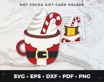 Puede incluir: Una taza roja y blanca de Papá Noel con una cobertura de crema batida blanca y un bastón de caramelo rojo y blanco. La taza está diseñada para contener una tarjeta de regalo. "Tarjeta de regalo" está escrito en el lateral de la taza.