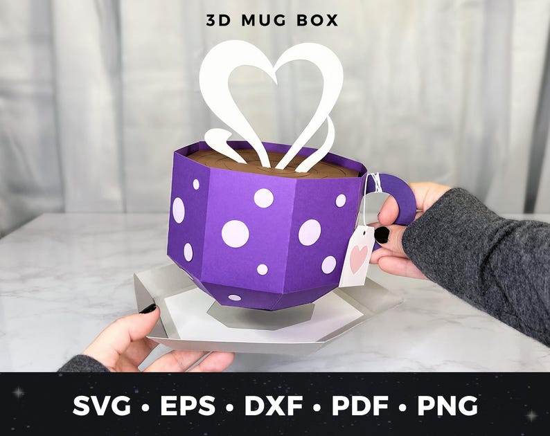 May include: A purple 3D mug box with white polka dots and a white heart-shaped steam design. The box is open and a hand is holding the mug handle. The box is on a white surface. 3D MUG BOX, SVG, EPS, DXF, PDF, PNG.