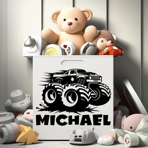 May include: White toy storage box with a black monster truck graphic and the name "MICHAEL" printed on the front. The box is filled with stuffed animals and toys.