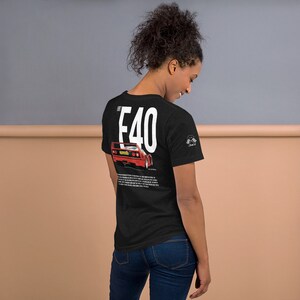 以下が含まれることがあります： 赤いフェラーリF40スポーツカーの白いグラフィックがプリントされた黒いTシャツ。車の真上に「F40」という文字が大きな白い文字でプリントされています。