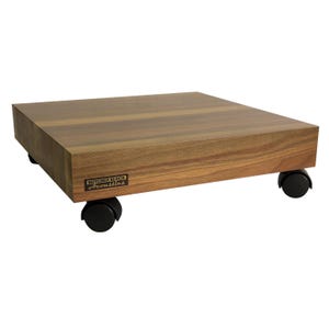 May include: A rectangular wooden platform with a natural brown wood grain finish, featuring four black swivel casters attached to the underside. A small rectangular label on the front edge displays the text Butcher Block Acoustics.