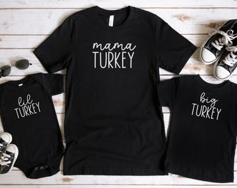May include: Three black t-shirts with white text. The largest shirt says "mama TURKEY". The medium shirt says "big TURKEY". The smallest shirt says "lil TURKEY".