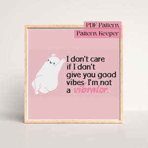May include: A framed cross-stitch pattern with a pink background and a white cartoon ghost. The text reads, "I don't care if I don't give you good vibes. I'm not a vibrator."