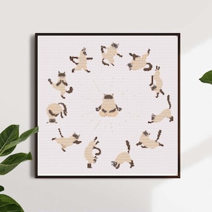 May include: A framed cross-stitch artwork featuring a circle of cartoon cats in various yoga poses. The cats are light brown with dark brown markings, set against a white background. The artwork is in a dark brown frame.