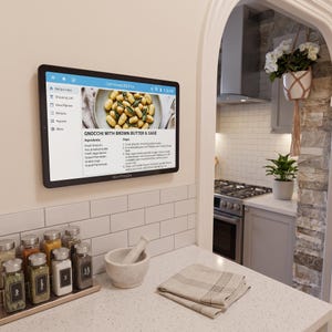 May include: A black wall-mounted digital tablet displaying a recipe for gnocchi with brown butter and sage. The screen shows a navigation menu on the left and cooking instructions on the right. The device is labeled WarmProLabs at the bottom.