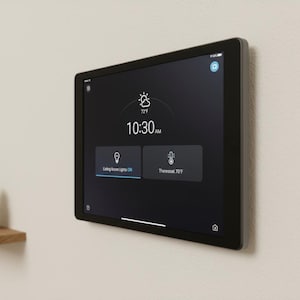 May include: A black smart home control panel mounted on a wall, displaying the time, weather, and control options. The screen shows 72°F and 10:30 AM. Buttons include "Living Room Lights On" and "Thermostat 70°F".