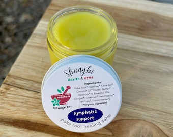 May include: A jar of yellow salve with the lid beside it. The lid is white with blue text that reads "lymphatic support poke root healing salve." The jar is labeled "Shuaybi Health & Home" and "homemade" with a net weight of 2 oz.