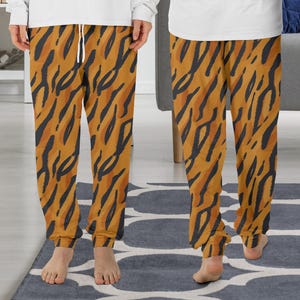 Puede incluir: Un pantalón de pijama marrón y negro con estampado y cintura con cordón.