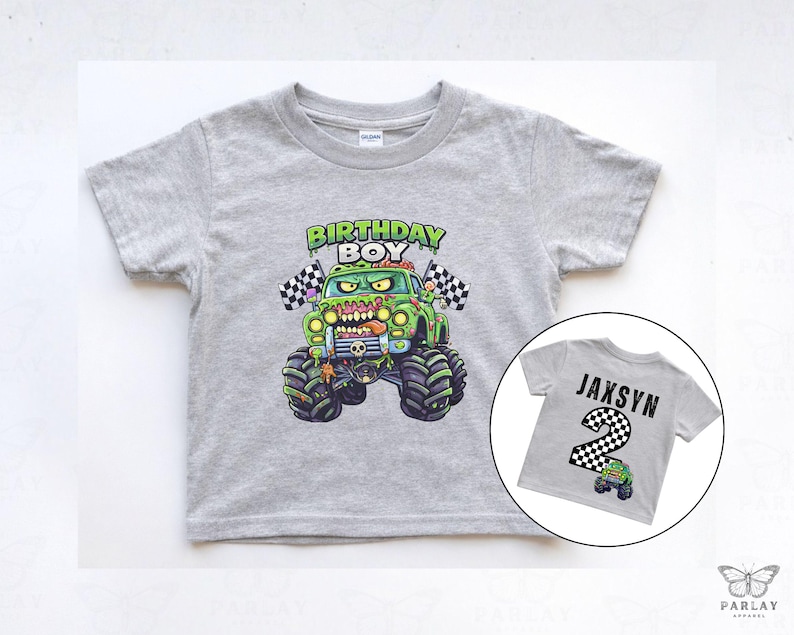 May include: A gray short-sleeved t-shirt featuring a green monster truck with the text "BIRTHDAY BOY". A smaller image shows a gray shirt with the name "JAXSYN" and the number "2".