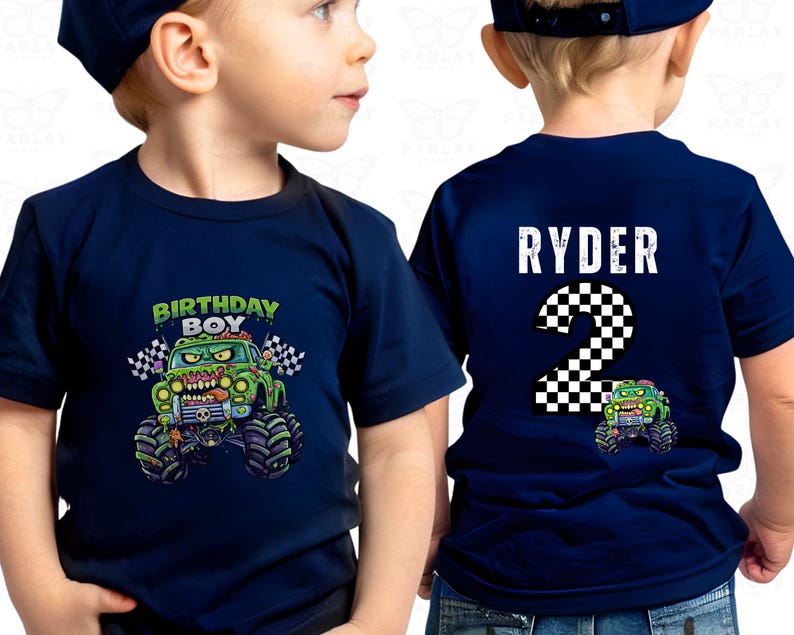 May include: Navy blue short-sleeved t-shirt featuring a monster truck design. The front displays "BIRTHDAY BOY" above a green monster truck with checkered flags. The back has "RYDER" and the number "2".