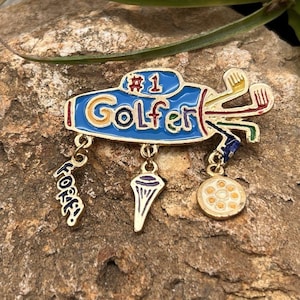 May include: A white ceramic mug with a black handle and the text "But First, Coffee" in a bold, black font. The mug is set against a blurred background, suggesting a cozy setting.