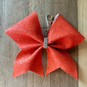 Llavero con lazo brillante de color sólido y tirador de cremallera, accesorio para mochila, bolso de baile de porristas