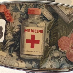 Puede incluir: Peque&ntilde;a caja rectangular con bordes plateados, con tem&aacute;tica m&eacute;dica vintage. El interior presenta una botella con la etiqueta "MEDICINE" con una cruz roja, pastillas y elementos florales. Tambi&eacute;n es visible el n&uacute;mero "13".