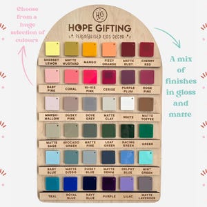 May include: Wooden display board featuring a wide array of color swatches in gloss and matte finishes. The board is labeled "HOPE GIFTING" and "PERSONALISED KIDS DECOR". Colors include Sherbet Lemon, Baby Pink, and Teal.