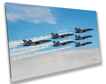 May include: A rectangular wall art print featuring six blue and yellow U.S. Navy fighter jets flying in a formation against a bright blue sky with white clouds. Each jet is marked with a unique number and the text U.S. NAVY on the side.