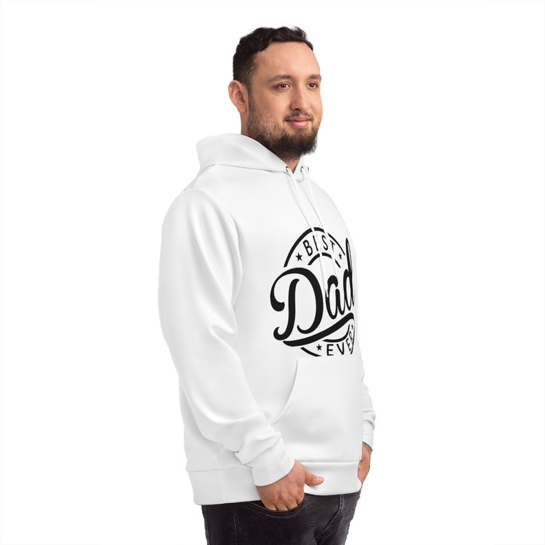 Może przedstawiać: Biała bluza z kapturem z przednią kieszenią i kapturem ze sznurkiem. Bluza z kapturem ma czarną grafikę z napisem "Best Dad Ever" w okrągłym wzorze. Osoba ma na sobie białą bluzę z kapturem.