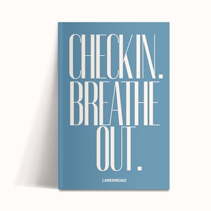K&ouml;nnte beinhalten: Ein blaues Buch mit den Worten "CHECKIN. BREATHE OUT." in gro&szlig;en wei&szlig;en Buchstaben. Das Wort "LARKINROAD" ist in kleinen wei&szlig;en Buchstaben unten aufgedruckt. Das Buch lehnt an einer wei&szlig;en Oberfl&auml;che.