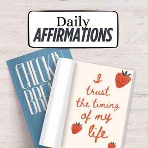 K&ouml;nnte beinhalten: Ein Stapel von Journalen. Oben steht "Daily Affirmations". Ein blaues Journal mit "Check In Breathe" und ein offenes mit "I trust the timing of my life" und Erdbeer-Illustrationen.