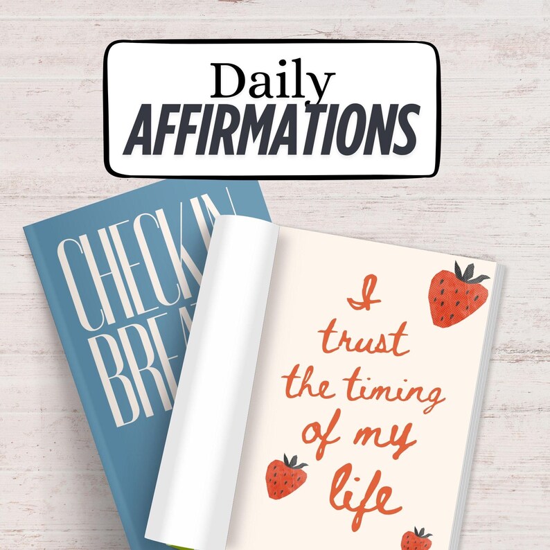 K&ouml;nnte beinhalten: Ein Stapel von Journalen. Oben steht "Daily Affirmations". Ein blaues Journal mit "Check In Breathe" und ein offenes mit "I trust the timing of my life" und Erdbeer-Illustrationen.