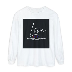 May include: White long-sleeve t-shirt with a black square graphic featuring the word "Love" in white script and the text "XOXO" and "Watch how it transforms your world".