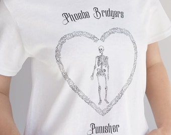 Op de afbeelding: Wit T-shirt met een zwart-witte afbeelding van een skelet in een hart met de tekst "Phoebe Bridgers" en "Punisher" gedrukt op de voorkant.