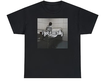 May include: A black t-shirt with a white graphic of a person sitting on a bed in a white room. The text "i got too silly" is printed below the image.