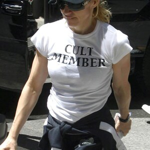May include: A woman wearing a white t-shirt with the text "CULT MEMBER" printed on it. She is also wearing a black baseball cap with the word "MAFIA" printed in red letters.