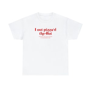 Pode incluir: Camiseta branca com texto vermelho que diz "I out pizza'd the-Hut and now the CIA is trying to assassinate me."