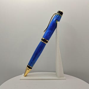 Op de afbeelding: Een set van drie keramische mokken met een gespikkelde, matte afwerking. De mokken zijn in crème, lichtgrijs en donkergrijs. Elke mok heeft een eenvoudig, minimalistisch ontwerp.