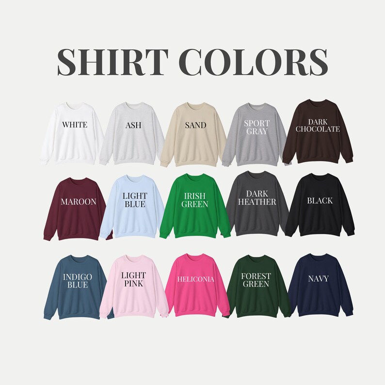 May include: A display of crewneck sweatshirts in various colors, including white, ash, sand, sport gray, dark chocolate, maroon, light blue, Irish green, dark heather, black, indigo blue, light pink, heliconia, forest green, and navy. The text "SHIRT COLORS" is at the top.
