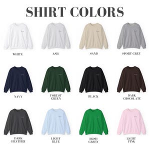 May include: A chart showing 12 different sweatshirt colors, including white, ash, sand, sport grey, navy, forest green, black, dark chocolate, dark heather, light blue, Irish green, and light pink.