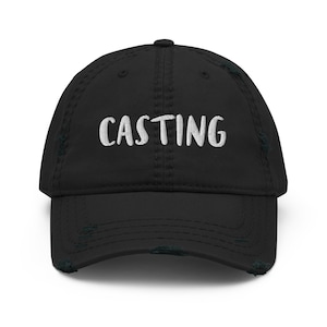Peut inclure: Casquette de baseball noire usée avec un texte brodé blanc qui dit "CASTING".