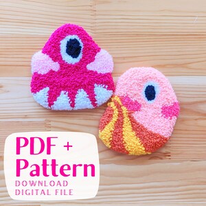 May include: Two colorful punch needle patterns, one pink with white accents and a single eye, the other peach with yellow and orange accents and a single eye. The text "PDF + Pattern DOWNLOAD DIGITAL FILE" is below the patterns.