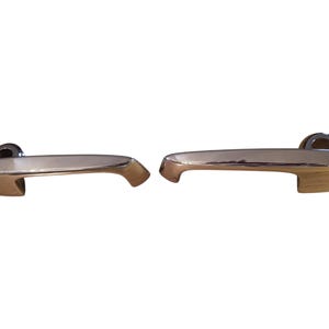 May include: Two chrome door handles with a curved design. The handles are in a horizontal position and are ready to be installed.
