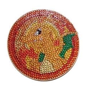 May include: A round, jeweled coaster featuring a cartoon character design. The coaster has a red border and is covered in small, colorful rhinestones in shades of yellow, orange, and green. The character has a smiling face.
