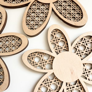 May include: Three wooden flower-shaped wall decor pieces with a woven pattern. The flowers are in various sizes and have a natural wood finish.