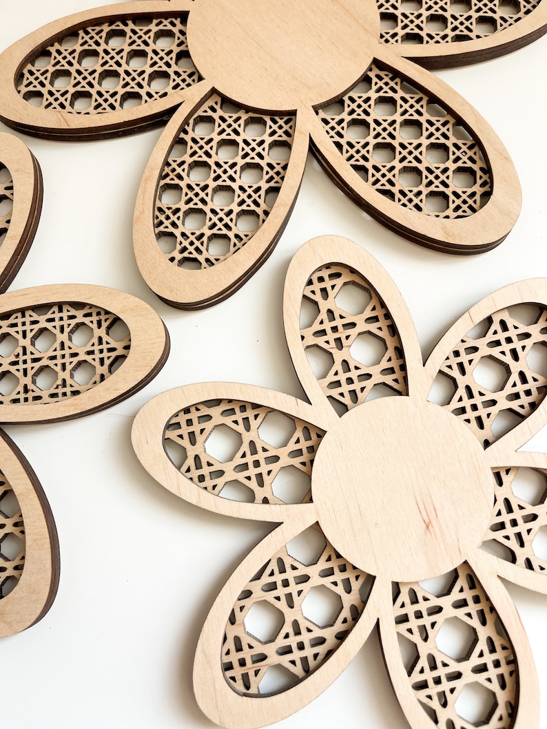 May include: Three wooden flower-shaped wall decor pieces with a woven pattern. The flowers are in various sizes and have a natural wood finish.