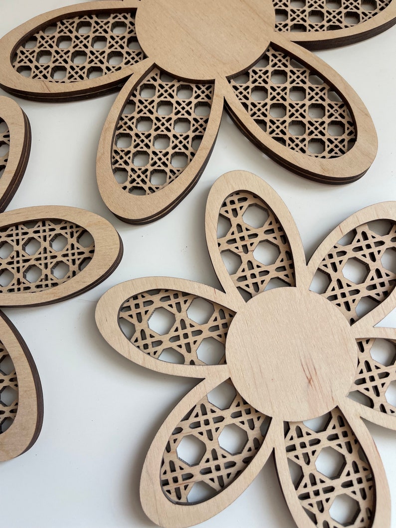 May include: Three wooden flower-shaped wall decor pieces with a woven pattern. The flowers are light brown and have a natural wood finish.