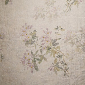 Pu&ograve; includere: Una carta da parati floreale vintage con un delicato motivo di fiori rosa chiaro e foglie verdi su uno sfondo crema.