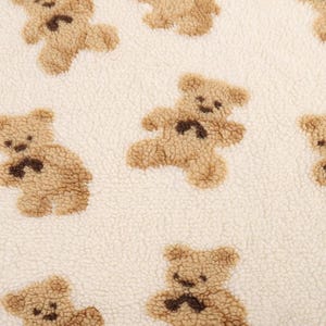 Könnte beinhalten: Weißer Stoff mit einem sich wiederholenden Muster aus braunen Teddybären. Die Bären sind alle nach vorne gerichtet und haben ihre Arme ausgestreckt.