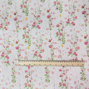 May include: White fabric with a pink and green floral pattern. The fabric is measured with a ruler that shows 30 inches.