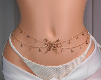 May include: A gold-toned waist chain featuring a central butterfly charm and smaller butterfly accents suspended along two delicate linked chains. The jewelry piece is worn over a white textured bikini bottom and a white sheer sarong wrap.