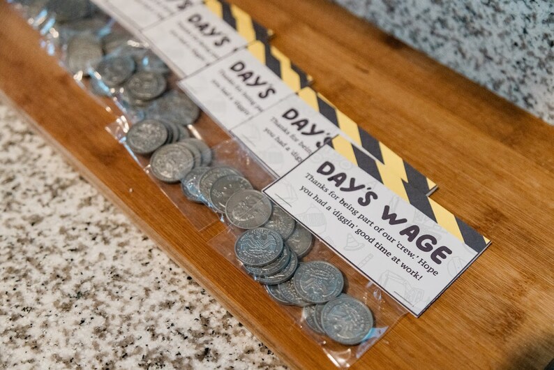 May include: A plastic bag filled with silver coins with a printed tag that reads "Day's Wage" with the text "Thanks for being part of our 'crew.' Hope you had a 'diggin' good time at work!"