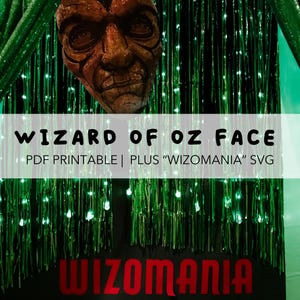 May include: A detailed, brown Wizard of Oz face mask hangs above text that reads "WIZARD OF OZ FACE" and "PDF PRINTABLE | PLUS "WIZOMANIA" SVG". Below the text, the word "WIZOMANIA" is displayed in red. The background is green.