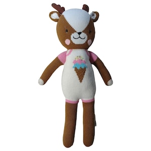 May include: A brown and white knitted deer doll with pink accents and an ice cream cone design on its chest. The doll has a friendly face with brown eyes and a pink nose.