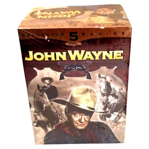 May include: A brown and gold box with a picture of John Wayne on the front. The box says "John Wayne Collector Series 5 Pack" on the front. The box is for a collection of John Wayne movies.