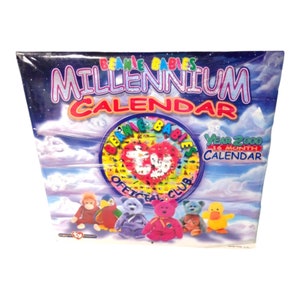 May include: A blue and purple calendar with the text "Beanie Babies Millennium Calendar" and "Year 2000 16 Month Calendar". The calendar features a circular image of various Beanie Babies with the text "Beanie Babies Official Club". There are five Beanie Babies at the bottom of the calendar.