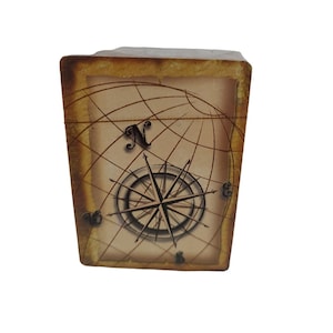 May include: A wooden box with a compass and a world map design. The compass has a black needle and a brown background. The map is in shades of brown and beige.