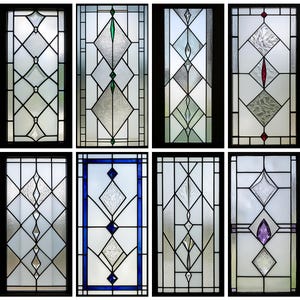 May include: A collection of eight stained glass window panels. Each panel features a unique geometric design with clear and textured glass, accented by colored glass elements in green, red, blue, and purple. The panels are framed in black.