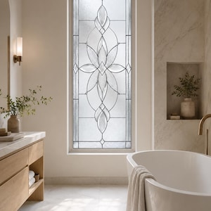 Puede incluir: Una ventana rectangular alta con un diseño decorativo de vidrio emplomado que presenta paneles de vidrio transparente y texturizado dispuestos en un patrón floral simétrico de pétalos alargados y formas geométricas con líneas negras.